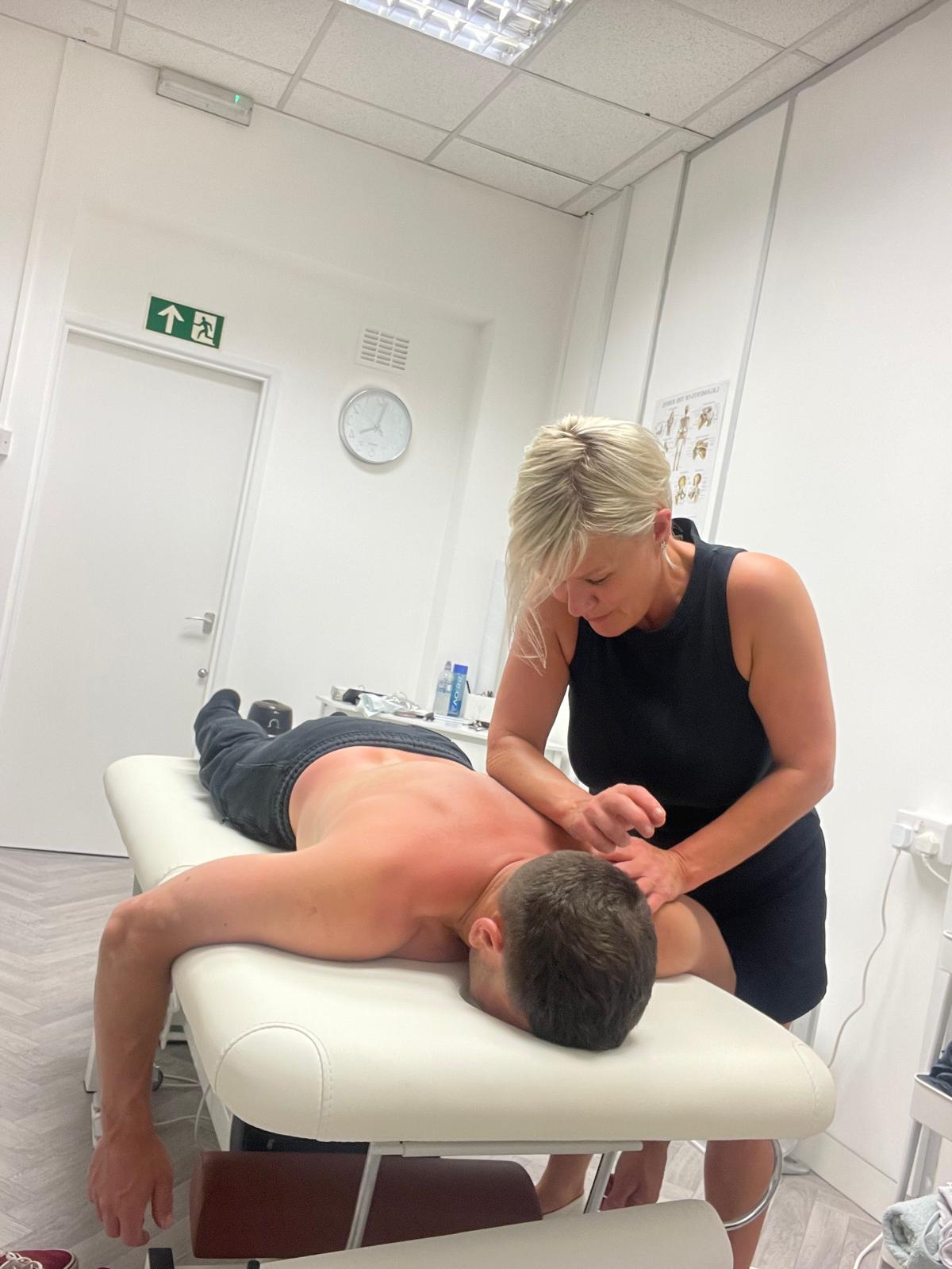 Lisa treating a client's shoulder and upper back
